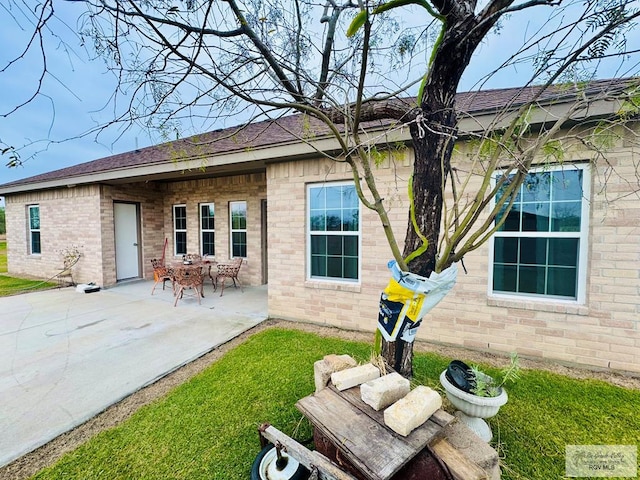 back of house featuring a patio area and a lawn