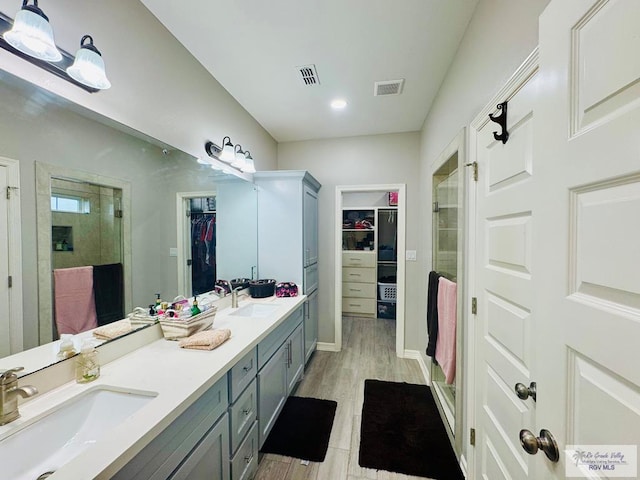 bathroom featuring hardwood / wood-style flooring, vanity, and a shower with shower door