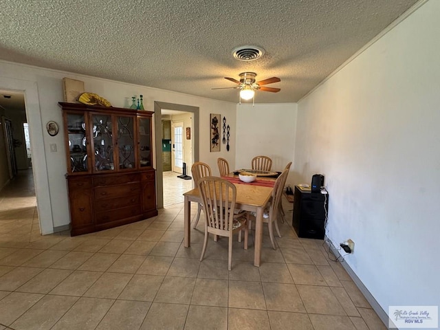 dining room featuring visible vents, a ceiling fan, a textured ceiling, and light tile patterned flooring