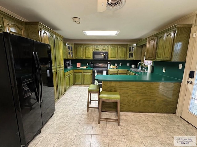 kitchen with a sink, a peninsula, visible vents, glass insert cabinets, and black appliances