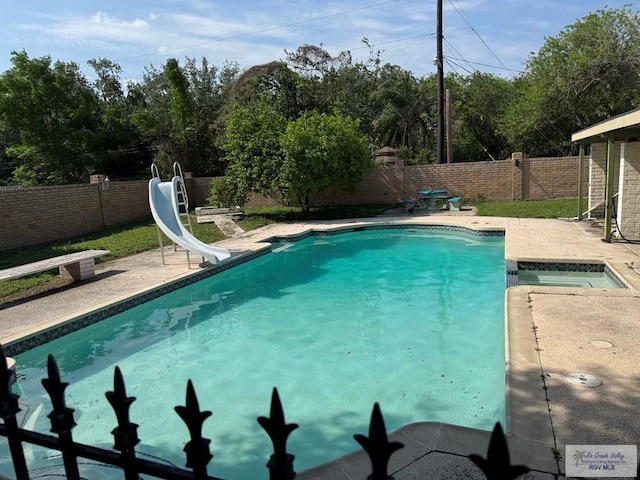 view of swimming pool with a water slide, a fenced in pool, a fenced backyard, and a patio area