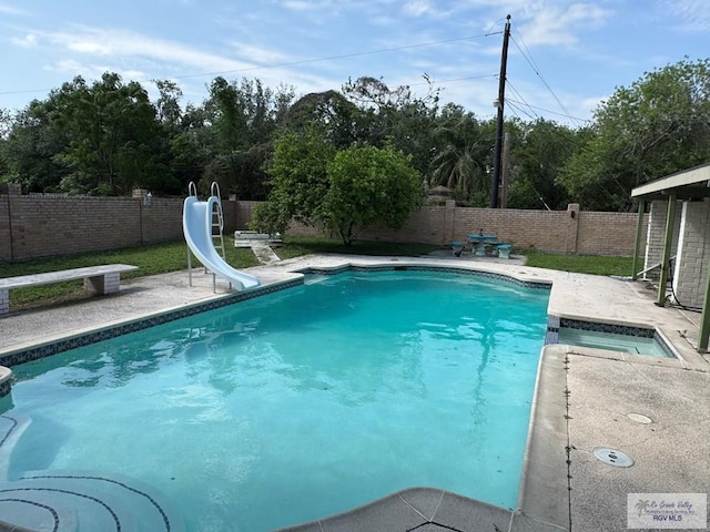 view of swimming pool featuring a fenced backyard, a fenced in pool, a water slide, and a patio