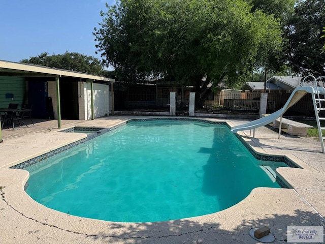 view of swimming pool with a patio, a water slide, a fenced backyard, and a fenced in pool