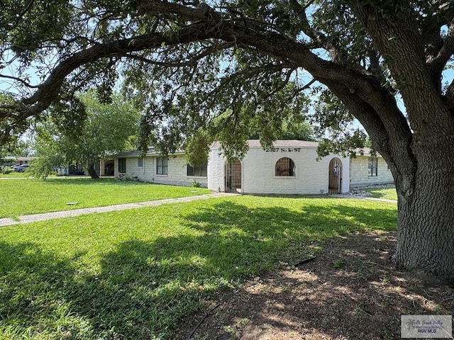 view of front of house with stone siding and a front lawn