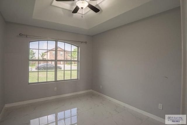 7549 Laurel Ave, Brownsville, TX 78526 - empty room featuring light marble finish floors, a raised ceiling, and a ceiling fan