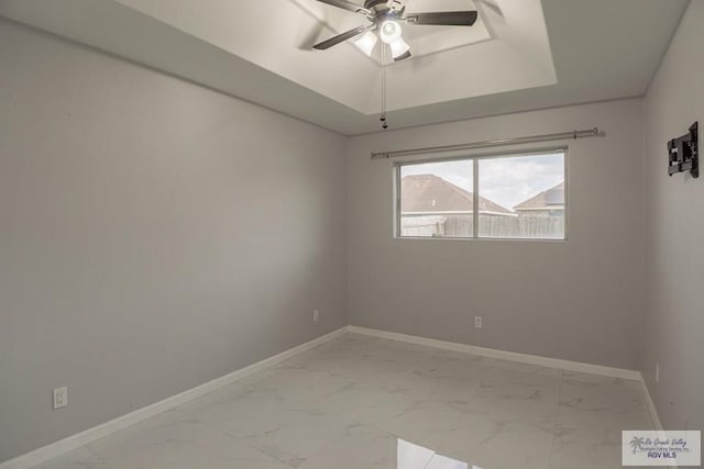 7549 Laurel Ave, Brownsville, TX 78526 - spare room featuring light marble finish flooring, ceiling fan, and a raised ceiling