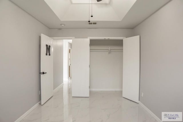 7549 Laurel Ave, Brownsville, TX 78526 - unfurnished bedroom with light marble finish floors, a closet, ceiling fan, and a raised ceiling