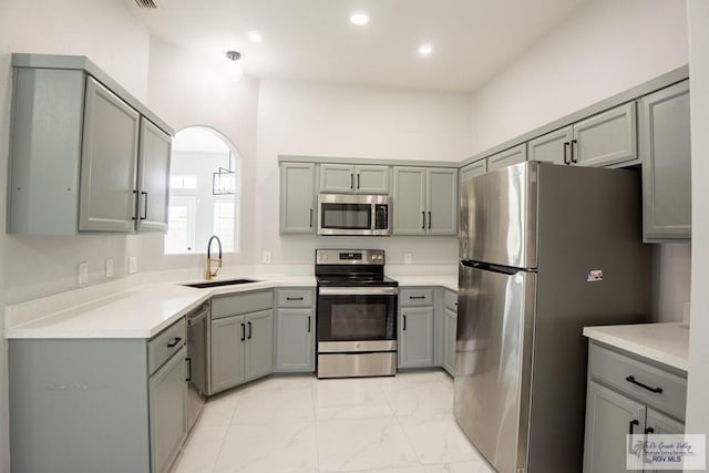 7549 Laurel Ave, Brownsville, TX 78526 - kitchen with appliances with stainless steel finishes, gray cabinetry, light marble finish floors, recessed lighting, and light countertops