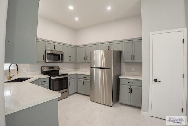 7549 Laurel Ave, Brownsville, TX 78526 - kitchen featuring stainless steel appliances, gray cabinetry, light marble finish floors, light stone countertops, and recessed lighting