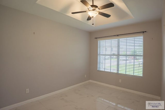 7549 Laurel Ave, Brownsville, TX 78526 - spare room featuring light marble finish flooring, a ceiling fan, and a tray ceiling