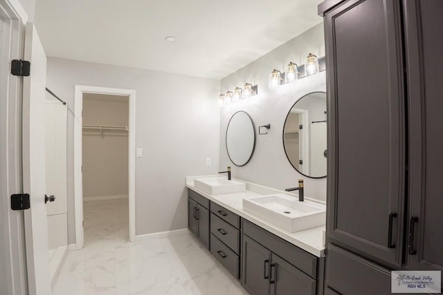 7549 Laurel Ave, Brownsville, TX 78526 - bathroom featuring marble finish flooring, double vanity, and a spacious closet