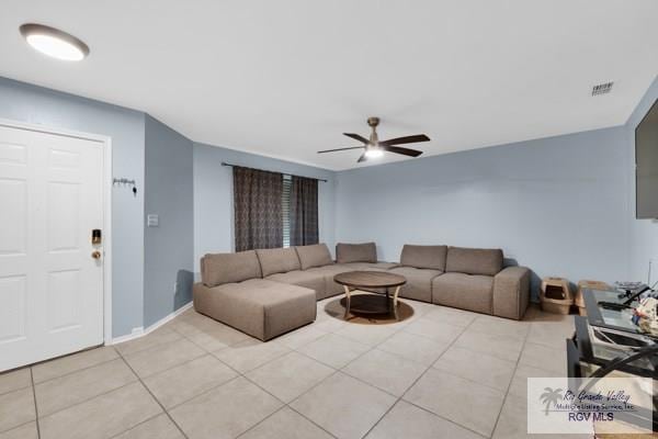 living room featuring a ceiling fan, visible vents, baseboards, and light tile patterned flooring