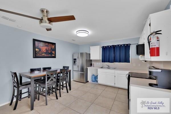 kitchen with light tile patterned floors, a ceiling fan, white cabinets, light countertops, and stainless steel fridge with ice dispenser