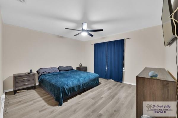 bedroom with light wood-style floors, ceiling fan, and baseboards