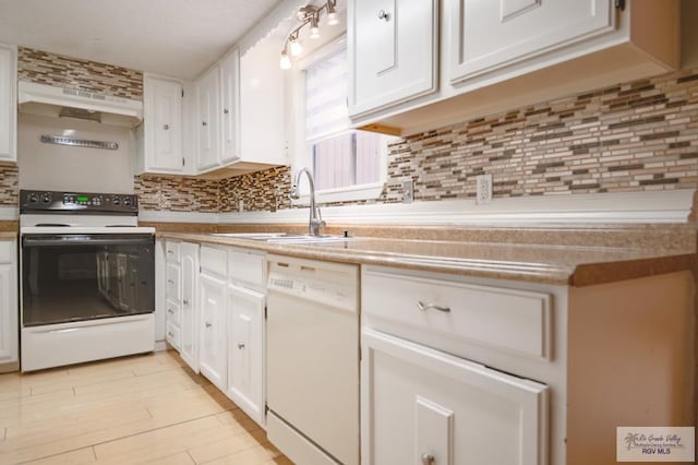 kitchen featuring light countertops, white appliances, a sink, and white cabinetry