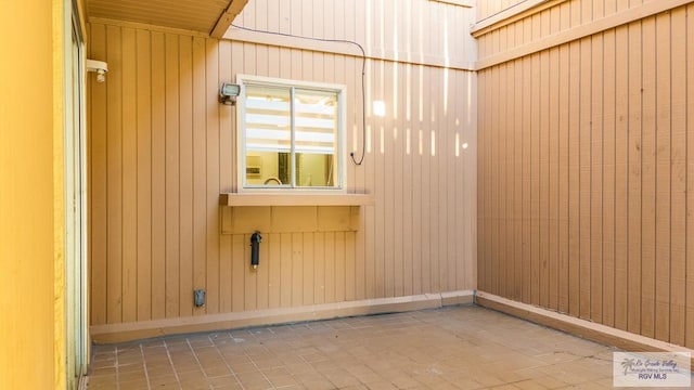 spare room with wood walls and baseboards