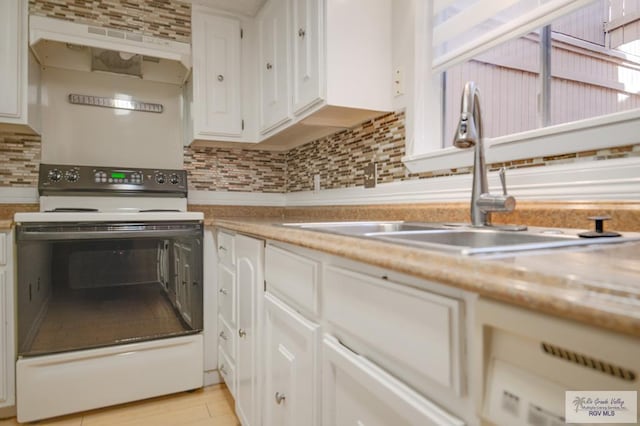 kitchen with decorative backsplash, ventilation hood, sink, electric stove, and white cabinetry