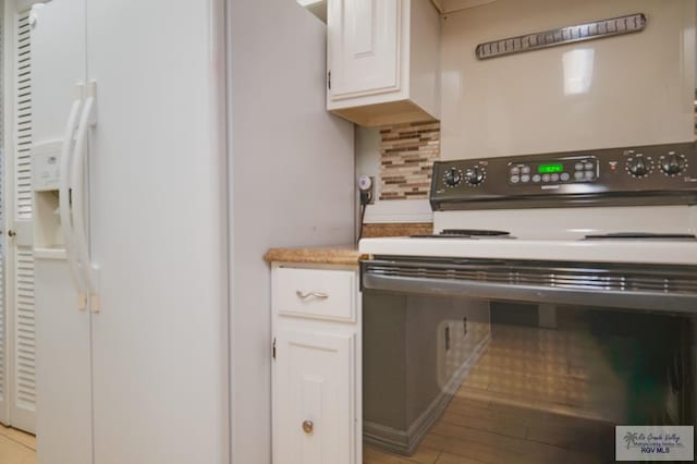 kitchen featuring light wood-type flooring, white appliances, tasteful backsplash, and white cabinetry