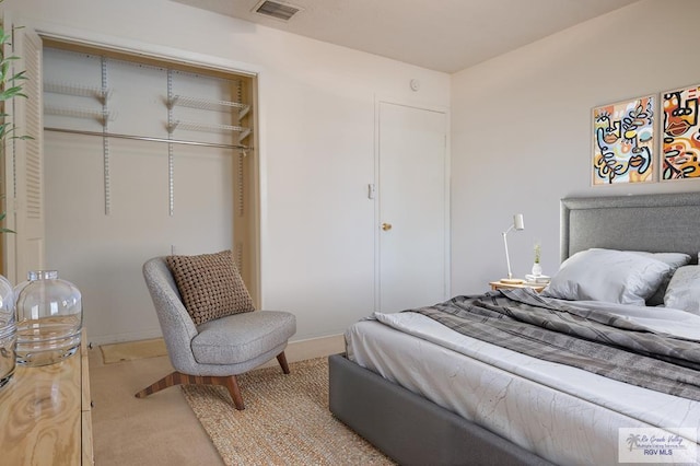 bedroom with a closet, carpet, visible vents, and baseboards