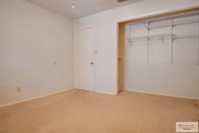 unfurnished bedroom with carpet floors, baseboards, visible vents, and a closet