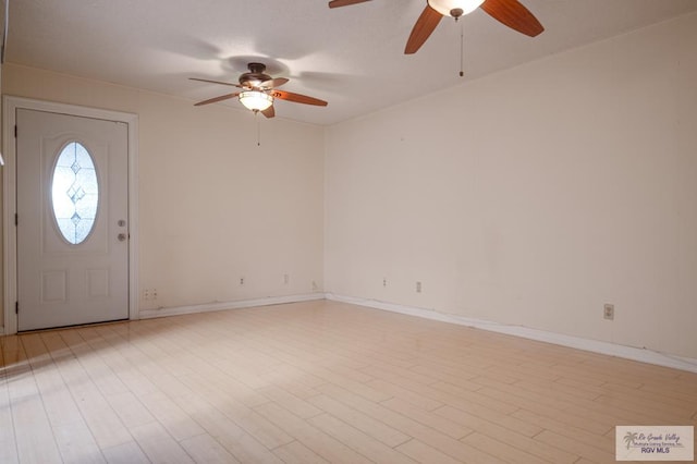 foyer entrance featuring ceiling fan, light wood-style flooring, and baseboards