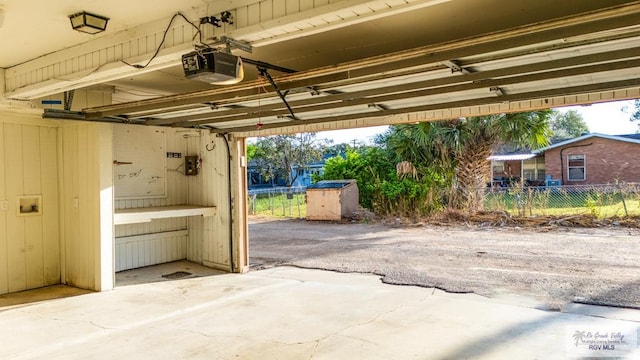 garage with a garage door opener and fence