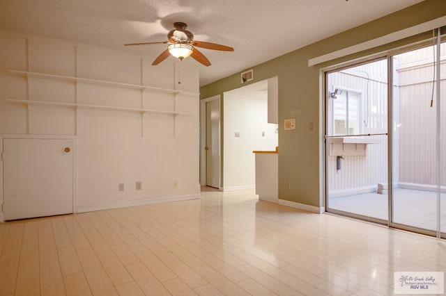 empty room featuring visible vents, baseboards, ceiling fan, a textured ceiling, and light wood-style floors