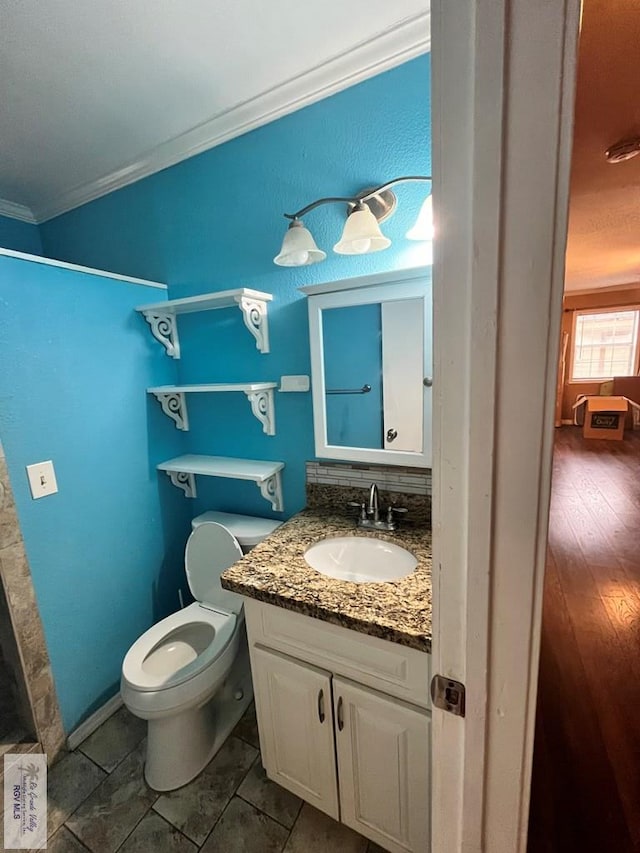 bathroom featuring a shower, crown molding, vanity, and toilet