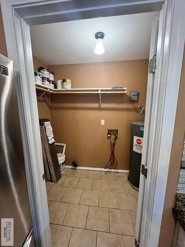 washroom with light tile patterned flooring, hookup for a washing machine, and water heater