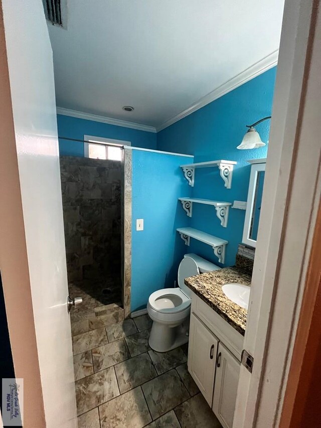 bathroom featuring vanity, toilet, crown molding, and walk in shower