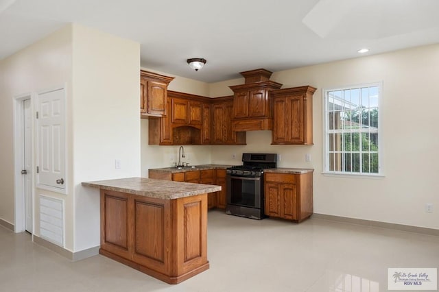 kitchen featuring kitchen peninsula, range with gas cooktop, and sink