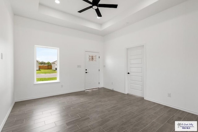 unfurnished room with a raised ceiling and ceiling fan