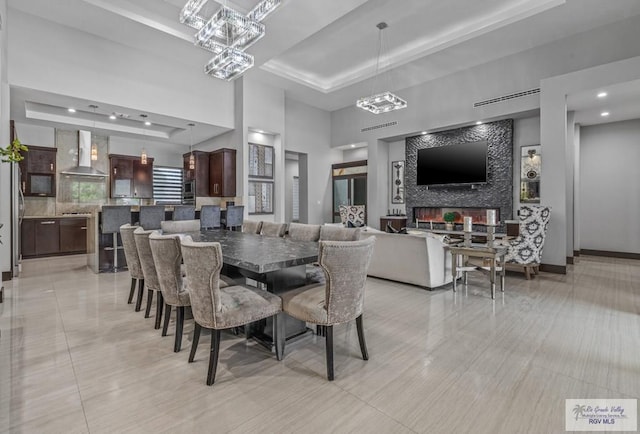 47 Medical St, Brownsville, TX 78520 - dining space featuring a tray ceiling, a chandelier, a high ceiling, light tile patterned flooring, and recessed lighting