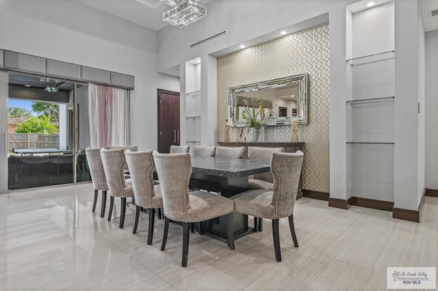 47 Medical St, Brownsville, TX 78520 - dining space featuring baseboards, a high ceiling, an accent wall, and wallpapered walls