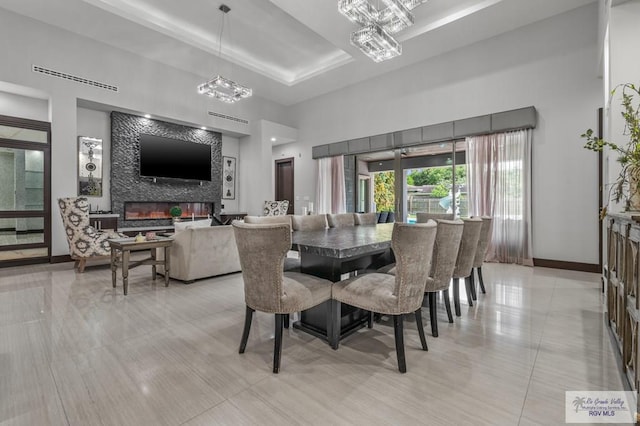 47 Medical St, Brownsville, TX 78520 - dining room featuring a towering ceiling, a fireplace, baseboards, a chandelier, and light tile patterned flooring