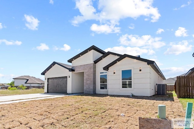 view of front of home with a garage and central AC