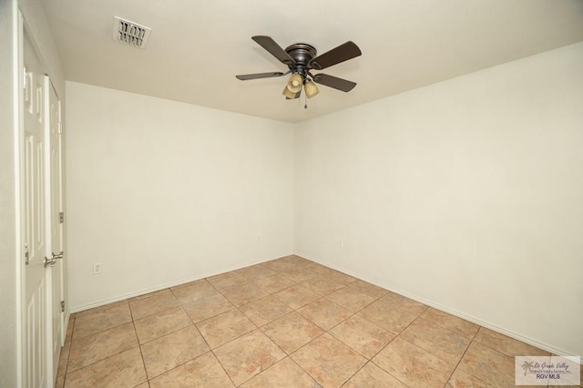 tiled spare room with ceiling fan