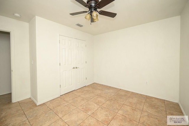 unfurnished bedroom featuring ceiling fan, light tile patterned floors, and a closet