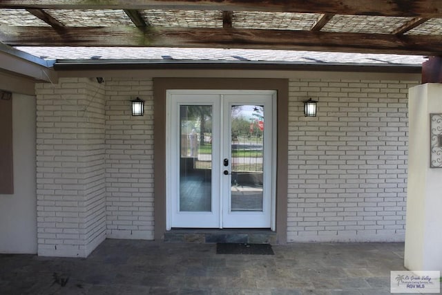 property entrance with brick siding and french doors