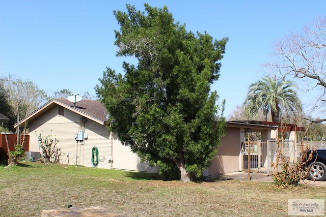 exterior space with central air condition unit, fence, and a yard