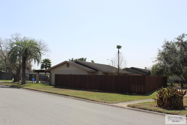 view of property exterior featuring fence, an attached garage, and a lawn