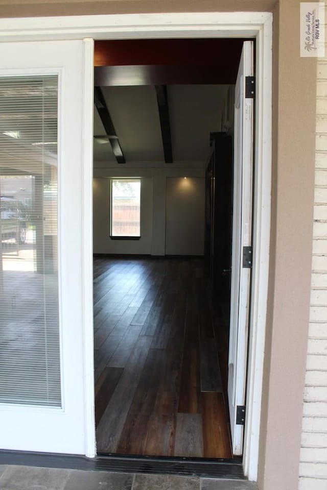 interior space with beam ceiling and dark wood-type flooring