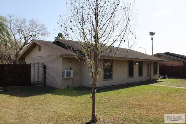 view of property exterior with a yard, a gate, brick siding, and fence