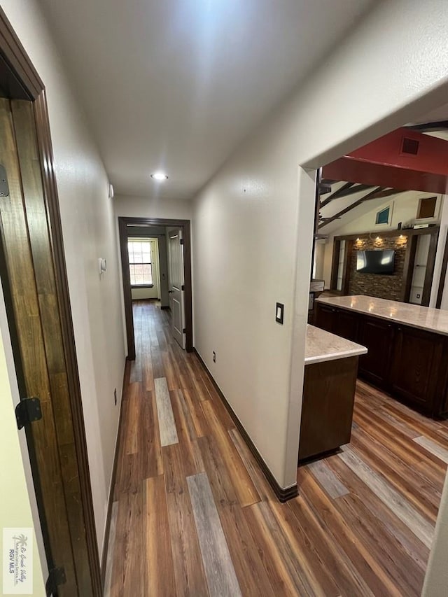 hallway with visible vents, dark wood finished floors, and baseboards