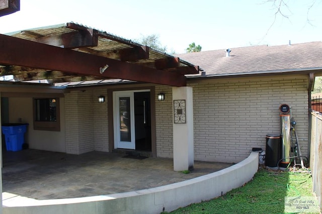 exterior space with brick siding and a shingled roof