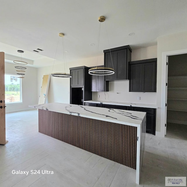1309 Thacker Ln, Harlingen, TX 78552 - kitchen featuring light countertops, a center island, pendant lighting, and dark cabinetry