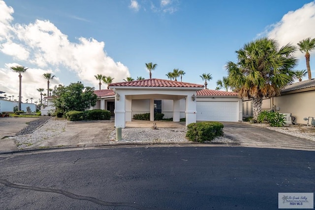 9 Sunshine Pl, Brownsville, TX 78526 - mediterranean / spanish house with driveway, stucco siding, a tile roof, and a garage