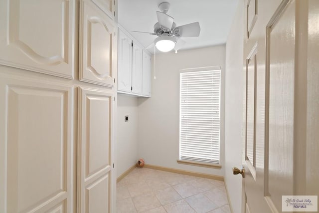 laundry area featuring electric dryer hookup, ceiling fan, light tile patterned floors, and cabinets