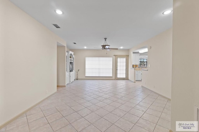 unfurnished living room featuring ceiling fan and light tile patterned floors