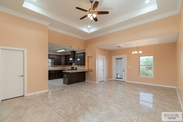 kitchen with pendant lighting, ceiling fan with notable chandelier, a tray ceiling, and crown molding